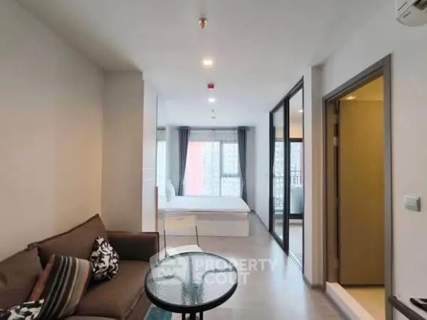 Modern apartment interior with cozy living area and bedroom, featuring large windows and stylish decor.