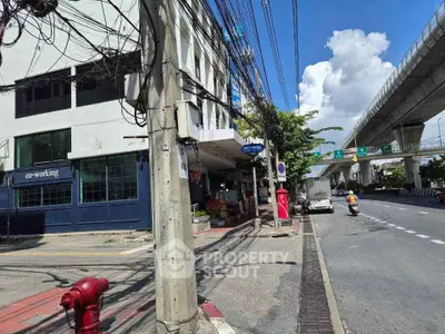 Street view of commercial building with co-working space and nearby highway