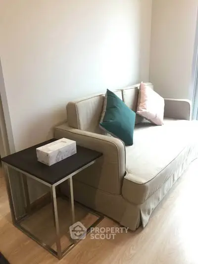 Modern living room with stylish beige sofa and sleek side table, perfect for cozy relaxation.