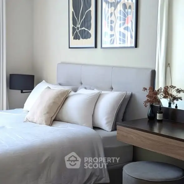 Elegant bedroom with modern decor and stylish artwork, featuring a cozy bed and chic furnishings.
