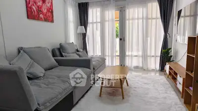 Charming living room with cozy gray sofa, wooden coffee table, and bright natural light.
