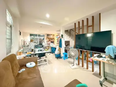 Spacious living room with modern decor and large TV, ideal for relaxation and entertainment.