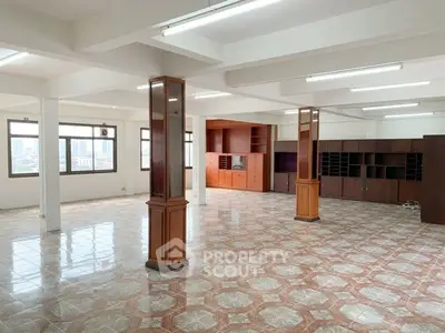 Spacious open-plan living area with tiled flooring and large windows offering city views.
