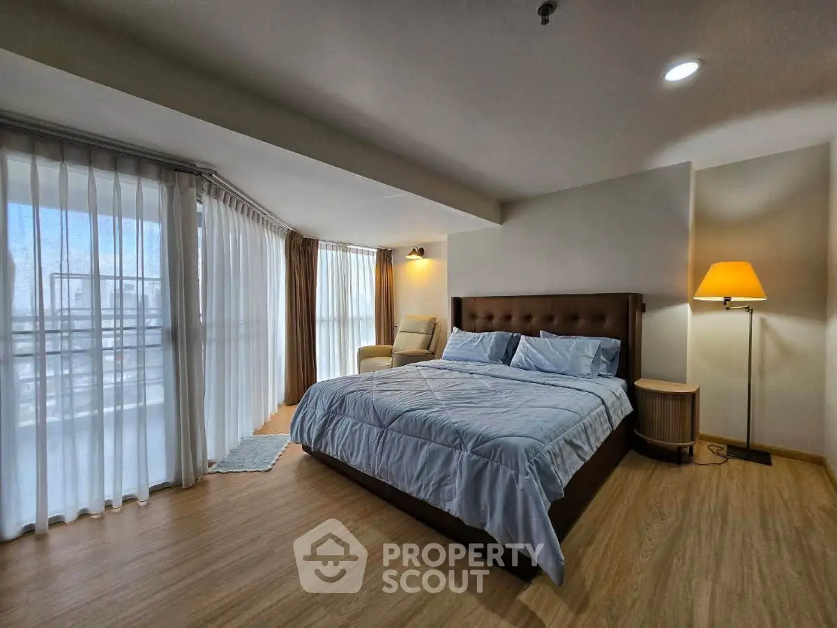 Spacious bedroom with large windows and modern decor