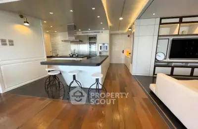 Luxurious open-layout kitchen with modern appliances and stylish bar seating in a contemporary home.