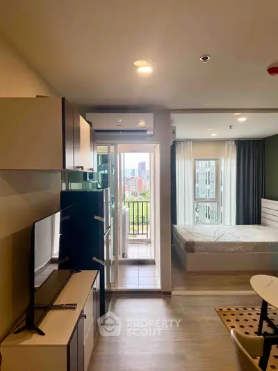 Modern studio apartment with balcony and city view, featuring sleek furnishings and ample natural light.