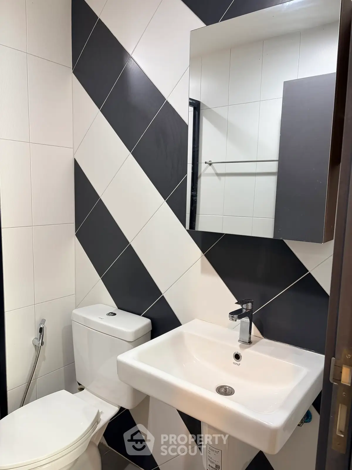 Modern bathroom with stylish black and white tile design and sleek fixtures.