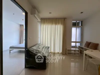 Modern apartment interior with living room and bedroom, featuring sleek design and natural light.