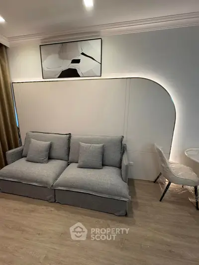Modern living room with stylish gray sofa and abstract wall art, perfect for contemporary living.