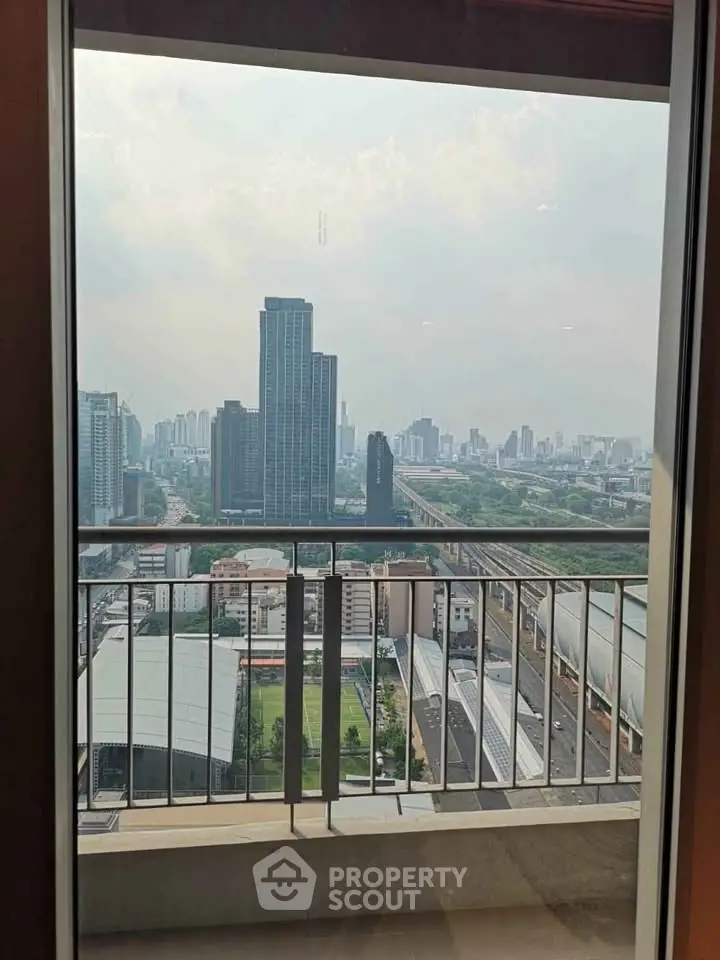 Stunning cityscape view from a high-rise balcony with modern railing and urban skyline.