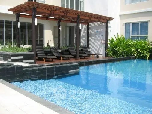Luxurious apartment complex with a stunning outdoor pool and stylish lounge area.