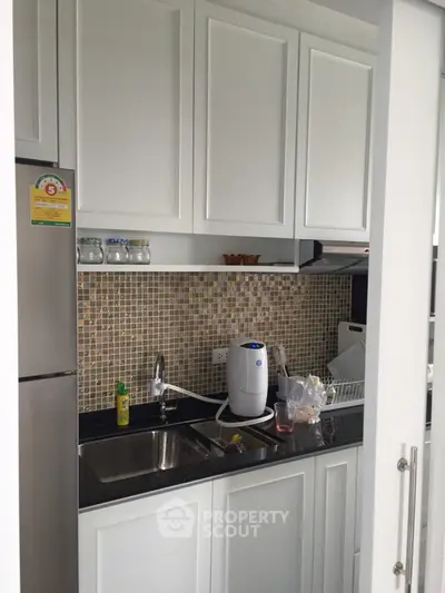 Modern kitchen with mosaic backsplash and sleek white cabinets