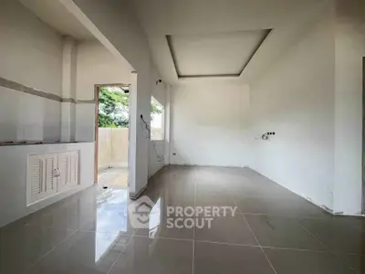Spacious unfurnished room with tiled flooring and large windows, ideal for customization.