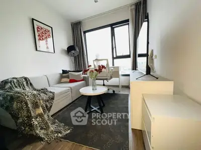 Modern living room with stylish decor and large window view.