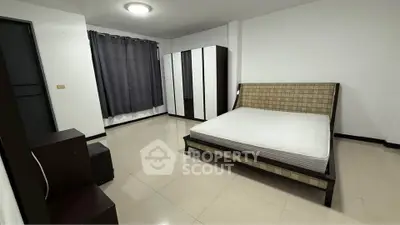 Spacious bedroom with modern furniture and ample natural light