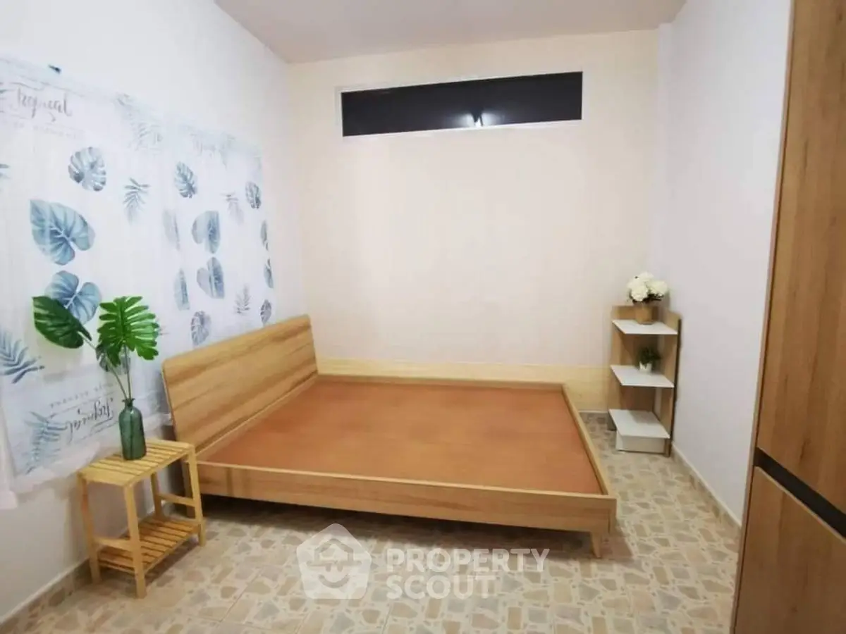 Minimalist bedroom with wooden bed frame and tropical decor accents