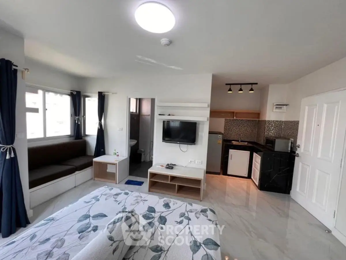 Modern studio apartment with open layout, featuring a cozy living area, compact kitchen, and stylish decor.