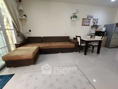 Spacious living room with modern furniture and dining area, featuring a cozy corner sofa and elegant decor.