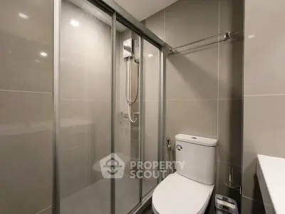 Modern bathroom with sleek shower and toilet in contemporary apartment.