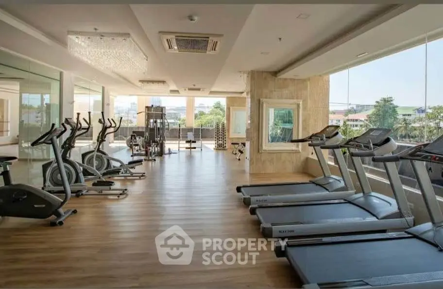 Spacious gym with modern equipment and scenic view, perfect for fitness enthusiasts.
