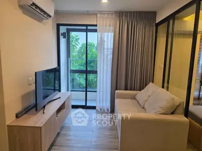 Modern living room with balcony view, featuring sleek furniture and natural light.