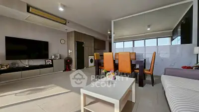 Spacious modern living room with dining area and large TV, perfect for family gatherings.