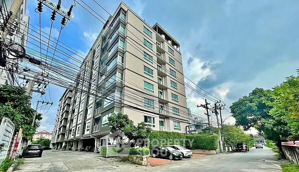 Modern apartment building with lush greenery and ample parking space