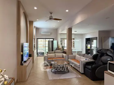 Spacious modern living room with stylish decor and open layout, featuring cozy seating and elegant lighting.