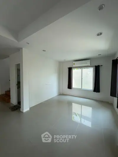 Spacious empty living room with large window and glossy tiled floor, perfect for customization.