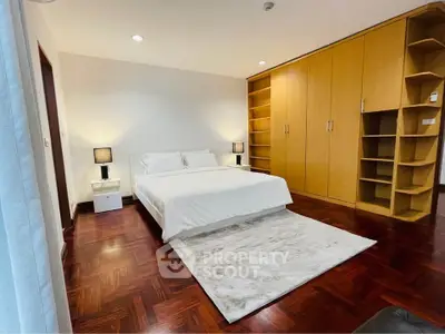Spacious bedroom with wooden flooring and built-in wardrobe