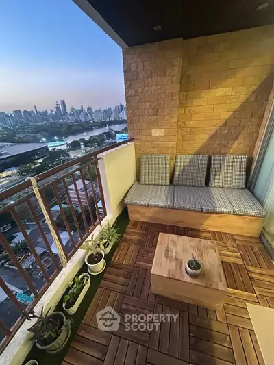 Charming balcony with cozy seating and stunning city skyline view at dusk.