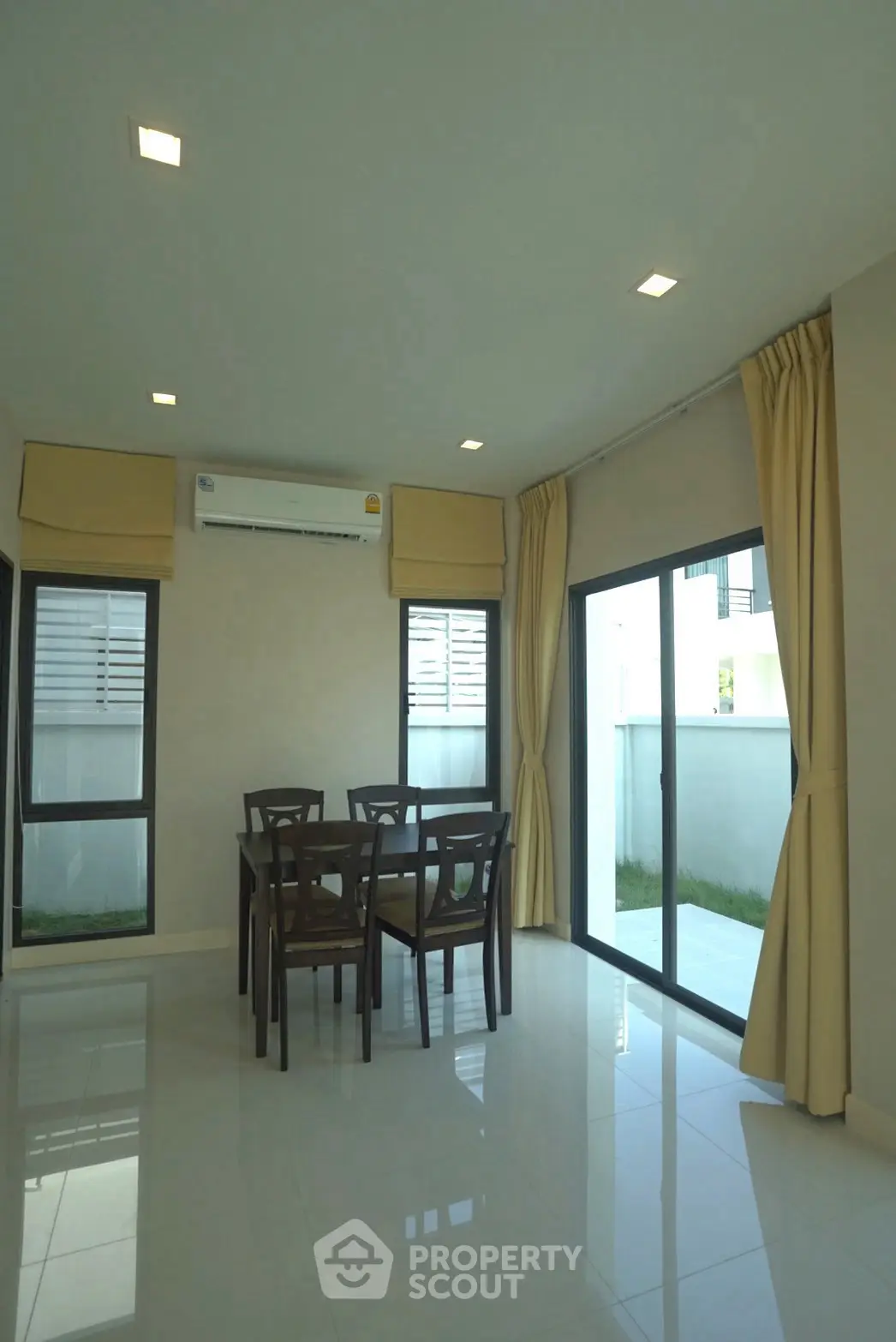 Bright dining area with modern furniture and large windows in a contemporary home.