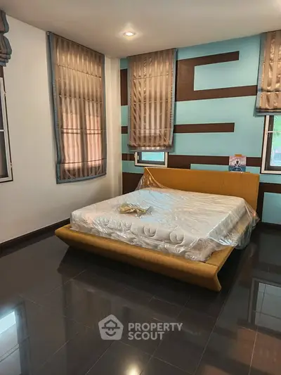 Spacious bedroom with modern design and large windows for natural light.