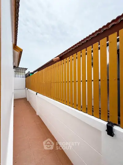 Charming outdoor balcony with privacy fence and tiled flooring, perfect for relaxation and enjoying fresh air.