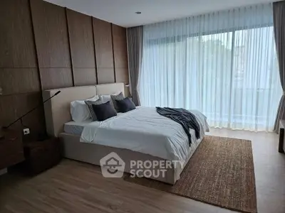 Luxurious bedroom with elegant decor and large window offering natural light