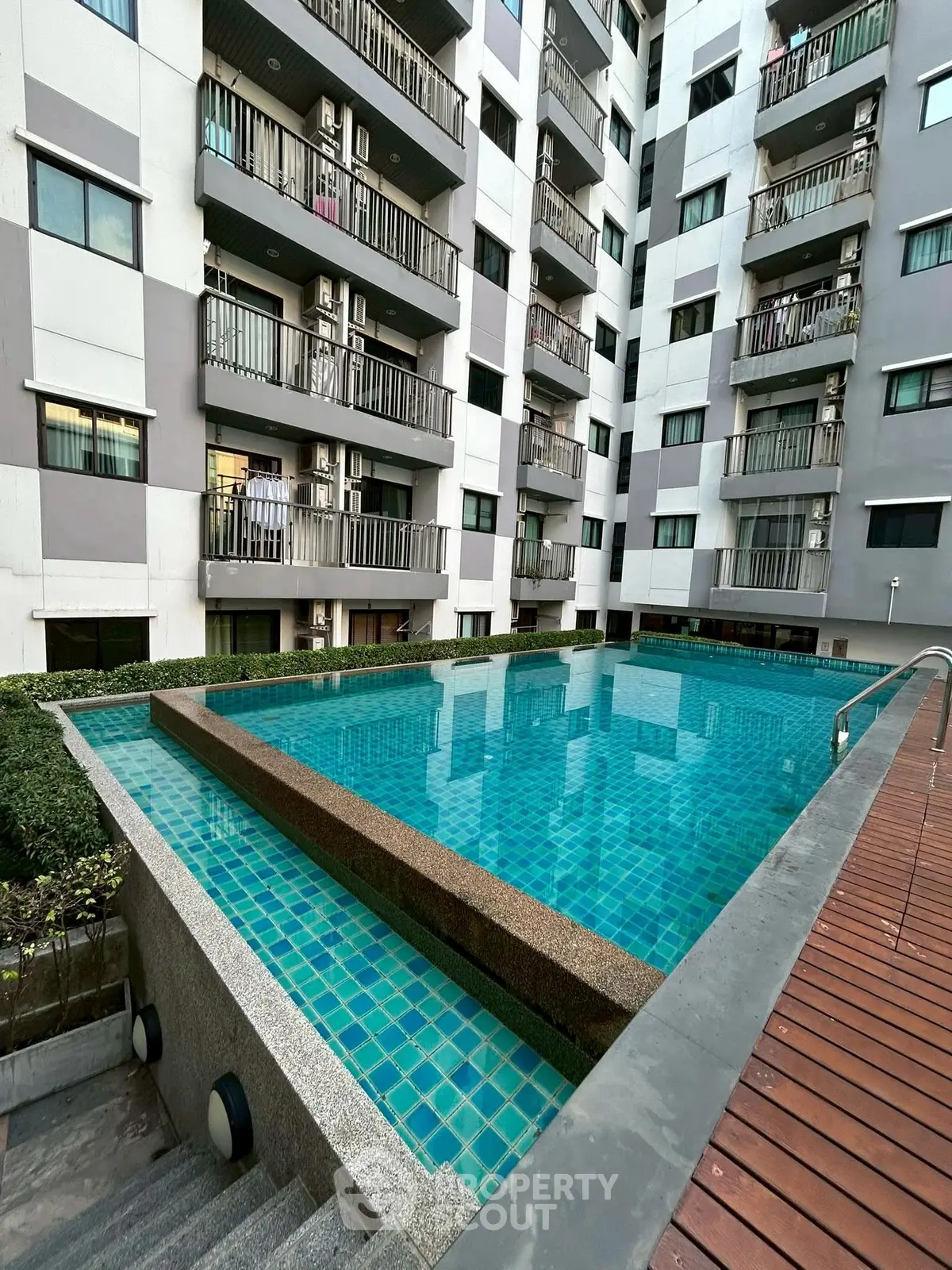 Modern apartment building with a stunning rooftop pool and spacious balconies.