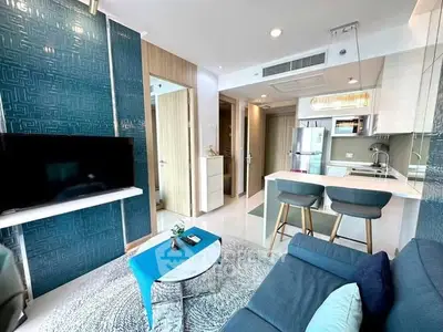 Modern living room with open kitchen, stylish decor, and cozy seating area in a contemporary apartment.