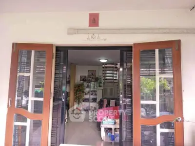 Charming home entrance with glass doors leading to cozy living room