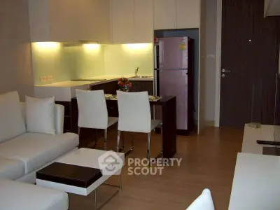 Modern open-plan living room with sleek kitchen and stylish furniture in a contemporary apartment.