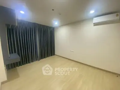 Spacious unfurnished room with wooden flooring and air conditioning, ideal for customization.