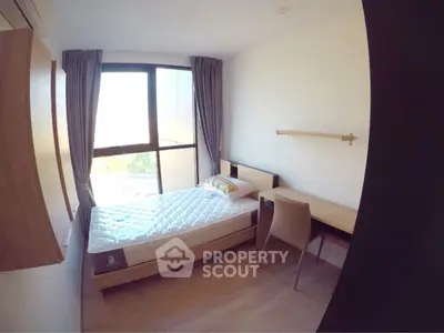 Modern bedroom with large window and minimalist furniture in a bright apartment.