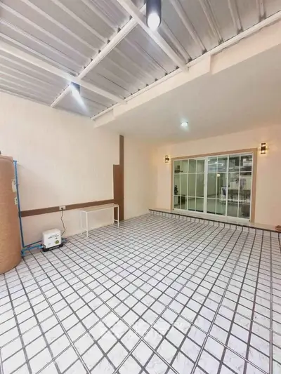 Spacious covered patio with tiled flooring and sliding glass doors, perfect for outdoor gatherings.