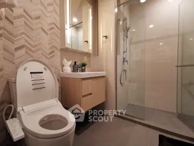 Modern bathroom with sleek shower and stylish vanity in contemporary apartment.