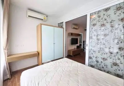 Modern bedroom with sliding glass doors and air conditioning in a stylish apartment.