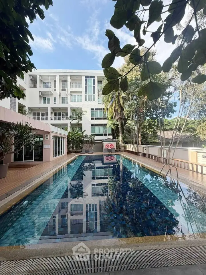 Luxurious apartment complex with a stunning outdoor pool and lush greenery, perfect for relaxation and leisure.