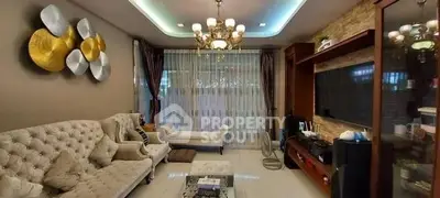 Elegant living room with plush seating and modern decor, featuring a large TV and stylish chandelier.