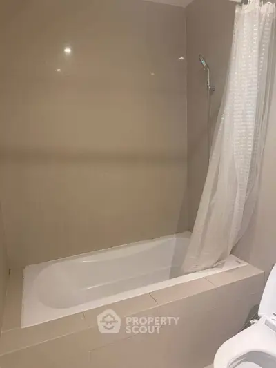 Modern bathroom with sleek bathtub and shower curtain in a minimalist design.