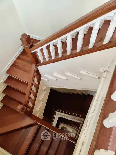 Elegant wooden staircase with classic white balusters in a multi-level home