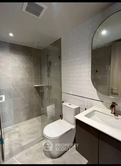 Modern bathroom with sleek design, featuring a glass shower and elegant fixtures.