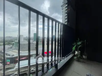 Stunning cityscape view from a modern balcony with sleek railing and potted plants.
